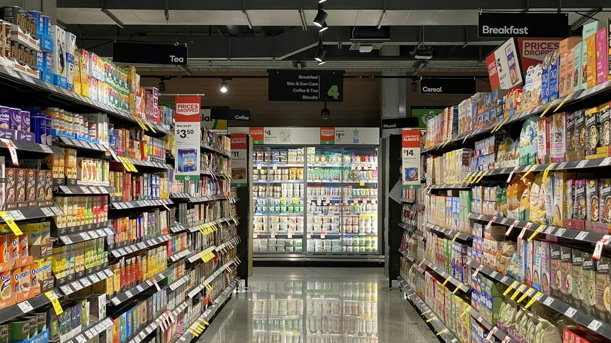 Διάδρομος σούπερ μάρκετ με ράφια τροφίμων και πινακίδες μειωμένων τιμών